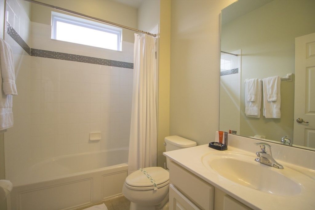 Une salle de bain avec une baignoire, des toilettes, un lavabo et une fenêtre.