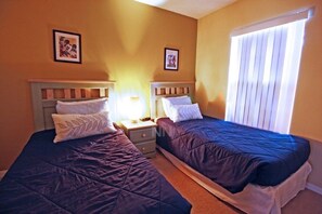 A room with two beds, each with a headboard and pillows, a nightstand, and a window with blinds. - Fv57771 - Emerald Island - 3 Bed 3 Baths Townhome (Kissimmee)