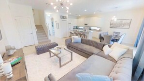 A modern living room with a sectional sofa, a coffee table, and a dining area in the background. - Aco237972 - Sonoma Resort - 6 Bed 4 Baths Villa (Kissimmee)