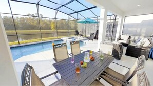 A covered outdoor area with a pool, seating, and a table with drinks and fruit. - Aco237972 - Sonoma Resort - 6 Bed 4 Baths Villa (Kissimmee)