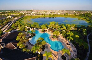 A resort with a large central pool surrounded by palm trees and a view of the surrounding area. - Fv43009 - Windsor Hills Resort - 6 Bed 4 Baths Villa (Kissimmee)