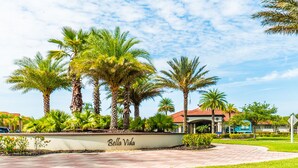 A landscaped area with palm trees and a sign that reads "Bella Vida." - Aco106374 - Bella Vida Resort - 4 Bed 3 Baths Townhouse (Kissimmee)