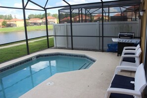 A covered outdoor swimming pool with a view of a lake and houses in the background. - Aco106374 - Bella Vida Resort - 4 Bed 3 Baths Townhouse (Kissimmee)