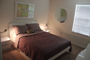 A bedroom with a bed, bedside tables, a lamp, a mirror, and artwork on the walls. - Aco106374 - Bella Vida Resort - 4 Bed 3 Baths Townhouse (Kissimmee)