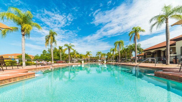 A clear swimming pool with lounge chairs and palm trees. - Aco106374 - Bella Vida Resort - 4 Bed 3 Baths Townhouse (Kissimmee)