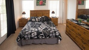 A bedroom with a large bed, two bedside tables, a dresser, a mirror, and a window with curtains. - Ip60382 - Fiesta Key - 4 Bed 3.5 Baths Townhome (Kissimmee)
