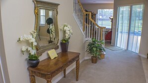 A wooden console table with a mirror, potted plants, and a framed picture. - Ip60138 - Highlands Reserve - 5 Bed 3 Baths Villa (Davenport)