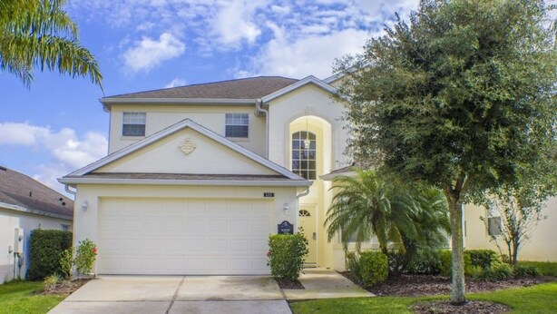 A two-story house with a garage, a small front yard with a palm tree, and a mailbox. - Ip60138 - Highlands Reserve - 5 Bed 3 Baths Villa (Davenport)