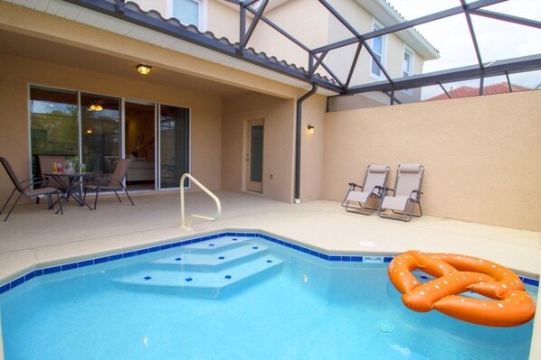 A swimming pool with steps, lounge chairs, and a covered patio area. - Aco253282 - Solterra Resort - 4 Bed 3 Baths Townhome (Davenport)