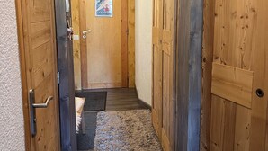 Ein schmaler Korridor mit Holztüren und einem Poster an der Wand.