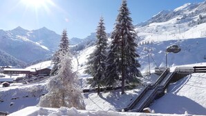 A snowy mountain landscape with snow-covered trees and a ski lift. - Cozy 4 Pax with Sunny Balcony (Méribel)