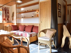 Um quarto aconchegante com uma cama de madeira, uma cadeira de vime e um banco de madeira.