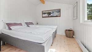A bedroom with a bed, a window, a painting, and a basket. - Larkollen vacation house (Moss)