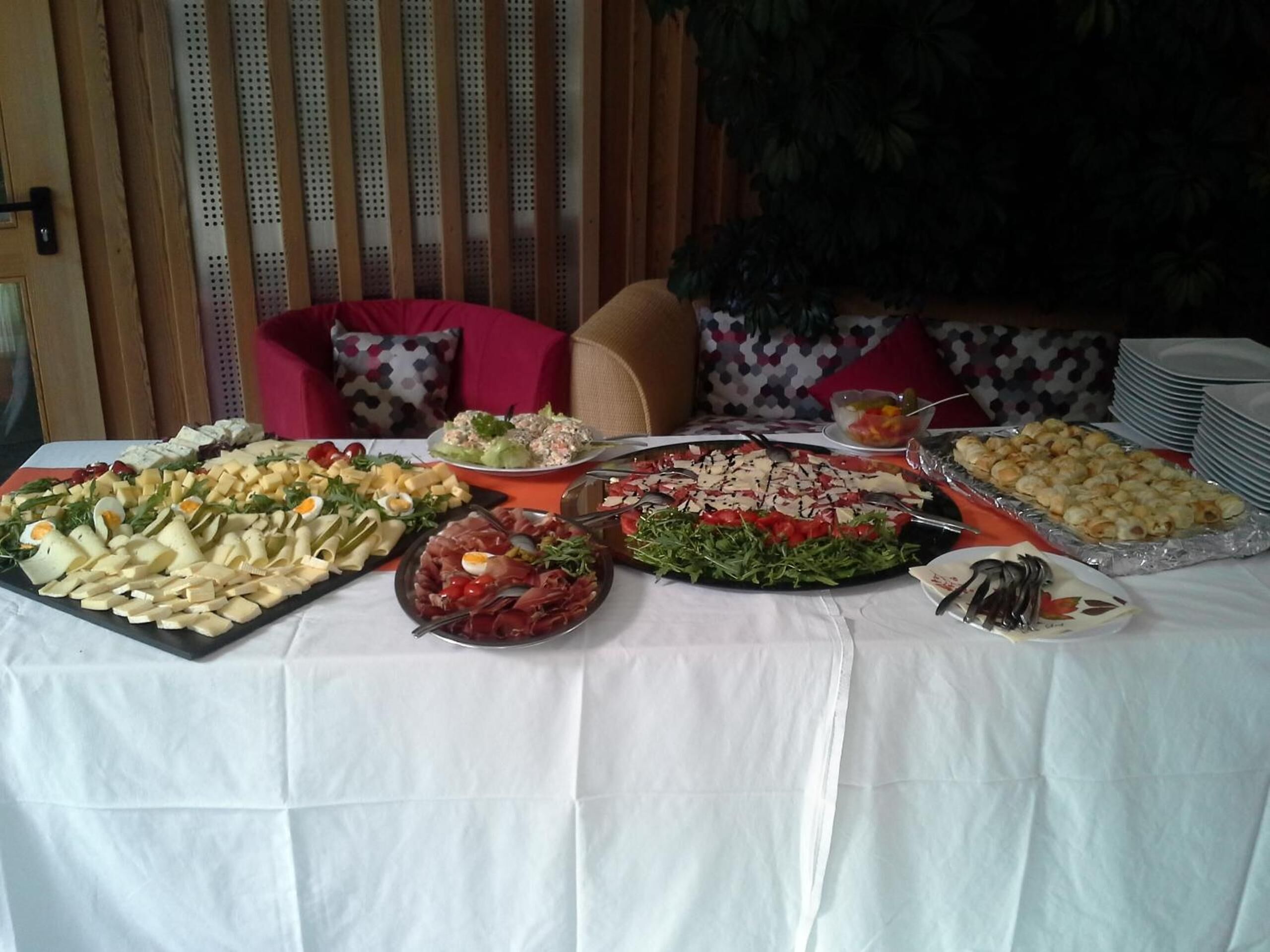 A buffet table with various food items including salads, meats, and pastries.