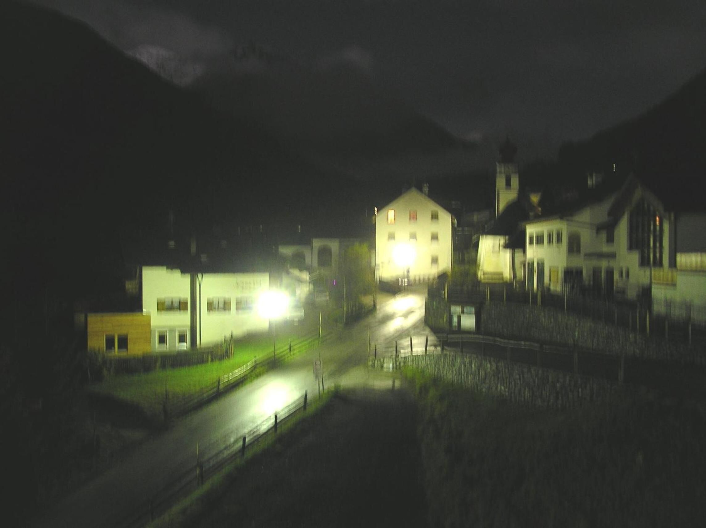 Una vista notturna di una città con edifici e una strada.