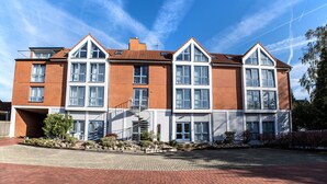 A multi-story residential building with a brick facade, large windows, and a central staircase. - Hotel am Kamp (Laatzen)