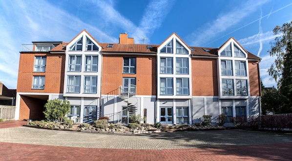 A multi-story residential building with a brick facade, large windows, and a central staircase. - Hotel am Kamp (Laatzen)