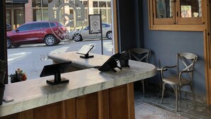 Ein Restaurant-Interieur mit Marmorplatte, Holzvertäfelung und Blick auf die Straße.
