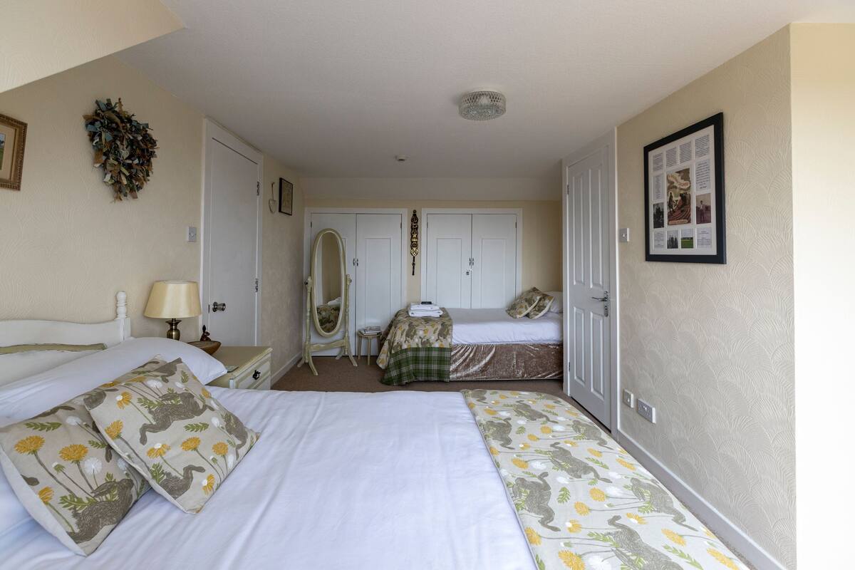 A hotel room with two beds, a vanity, and a mirror.