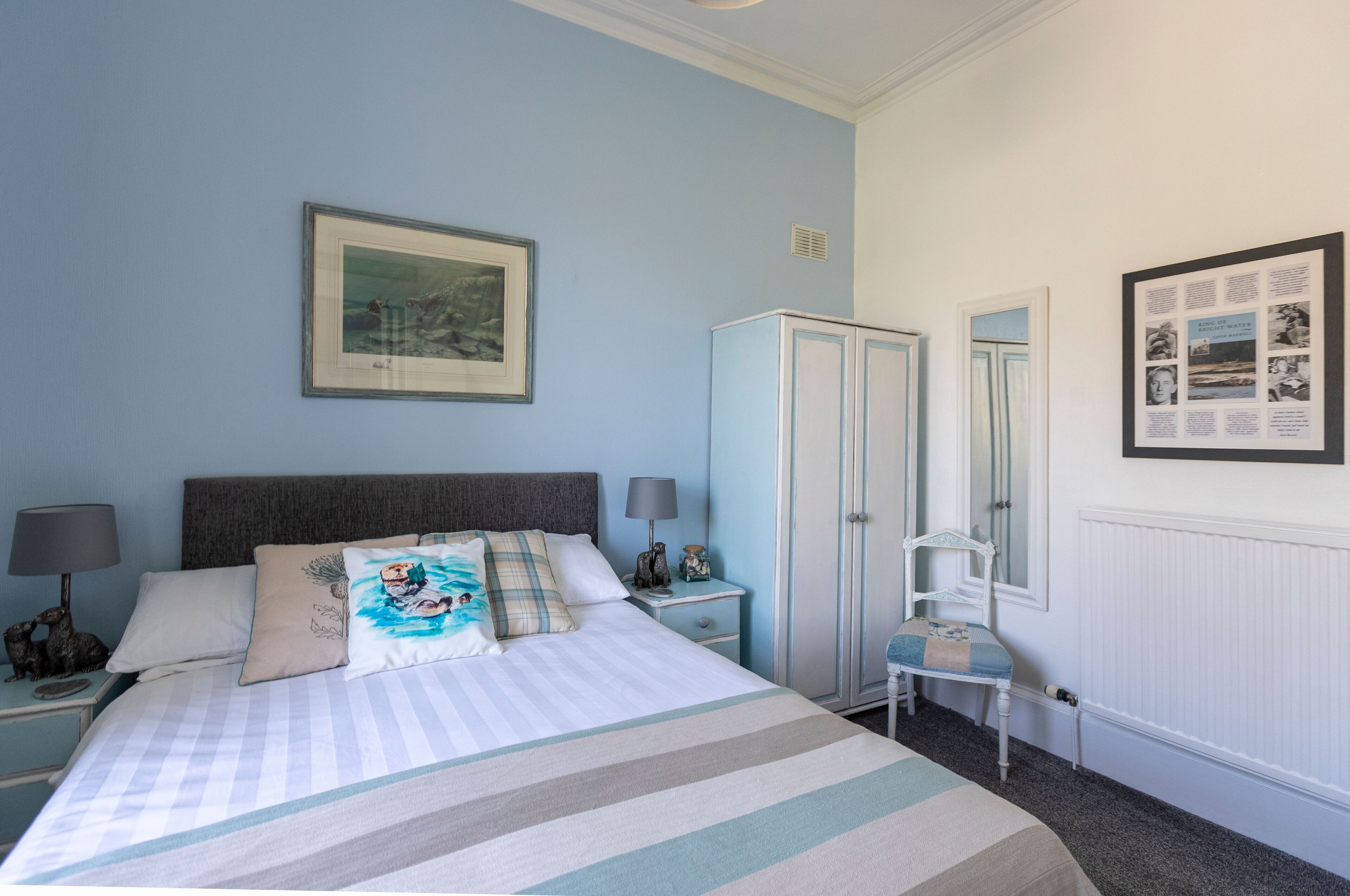 A neatly arranged bedroom with a bed, bedside tables, a wardrobe, and a chair.