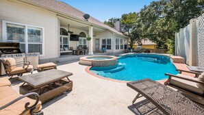 Un jardin avec une piscine, du mobilier d’extérieur et un patio couvert.