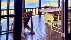 A wooden deck with a table and chairs, overlooking a coastal view. - Zandoli Villa
Simply Awesome Views (Cap Estate)