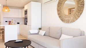 A modern living room with a sofa, a coffee table, and a round mirror on the wall. - APARTMENT A few meters from a black sand beach. (Santiago del Teide)