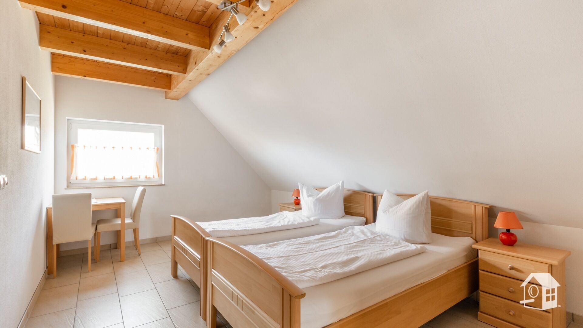 Un dormitorio con dos camas, un escritorio y una silla.