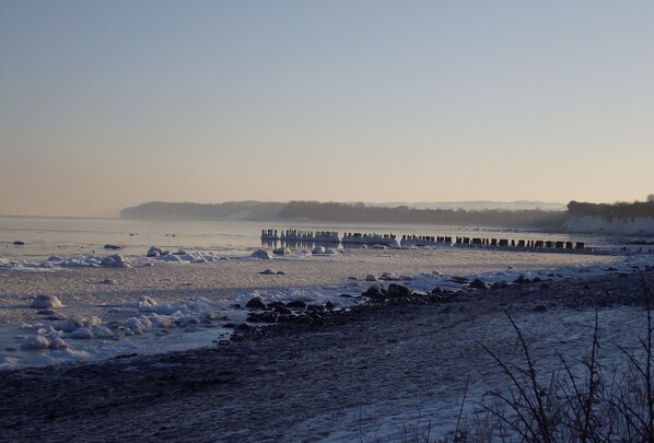 Stroll along the frozen lake, bordered by a rocky shoreline, and enjoy the serene atmosphere.