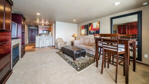 A spacious living area with a dining table and chairs, a sofa, and a kitchen in the background. - GrandView 306 - Luxury Waterfront Condo (Chelan)