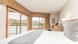 A hotel room with a large bed, a view of a lake, and a sign that says "GO JUMP IN THE LAKE". - GrandView #724 - Double Queen Suite (Chelan)