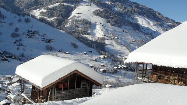 A snow-covered mountain landscape with wooden cabins and a clear sky. - At the base of the slopes, apartment with balcony/terrace, enclosed garage, nearby shops (Beaufort)