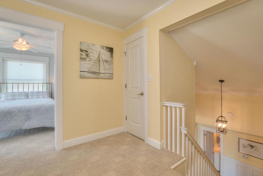 A bedroom with a bed, a ceiling fan, and a window with blinds.