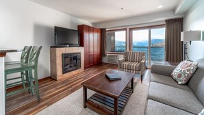 Un salon moderne avec une cheminée, un téléviseur, un canapé et une vue sur la mer.