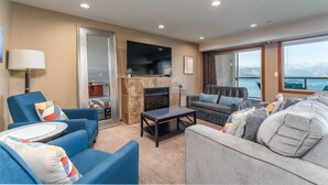 A living room with a fireplace, sofas, a coffee table, and a television. - Grandview 532 Executive Waterfront condo (Chelan)