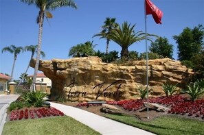 Explore the tranquil landscaped area featuring a striking rock formation with the inscription 'Terra Verde' and a picturesque pathway.