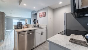 A modern kitchen with stainless steel appliances, a marble countertop, and a view to the outside. - GrandView 105 - Luxury Waterfront Condo (Chelan)