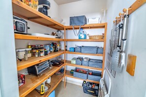 A well-organized storage area with shelves holding various kitchen items, containers, and a hanging rack with utensils. - ALL 4 Master Bedrooms Are Beachfront with King Beds, Remodeled in 2021 (Puerto Penasco)