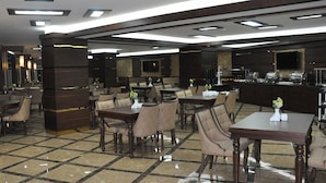 A spacious hotel lobby with multiple seating areas, a reception desk, and a buffet setup. - Alemdar Otel (Erzincan)