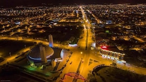 An aerial view of a city at night with illuminated streets, a prominent dome structure, and a bridge. - Alemdar Otel (Erzincan)