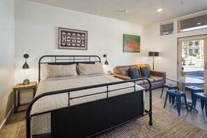 Ein Schlafzimmer mit Bett, einer Couch, einem Tisch und einem Stuhl.