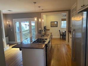 A modern kitchen with a central island, stainless steel appliances, and pendant lighting.