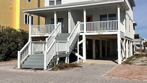 A two-story building with a balcony and a staircase leading to the second floor. - Duplex- What if I told you…You CAN afford Paradise! Make the Call today! 🤙 (Gulf Shores)