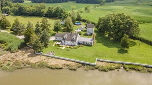 A large house with a well-maintained lawn and a swimming pool. - Water front home on the Cohansey River (Bridgeton)