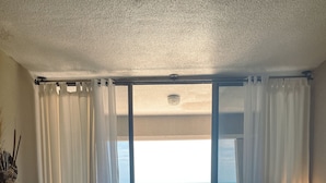 Hotellihuone, josta on näkymä merelle, ruokailutila, jossa on pöytä ja tuolit, sohva ja sohvapöytä.