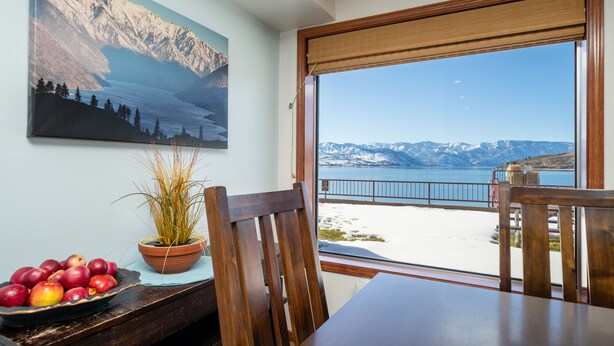 Comedor con vistas a una montaña nevada y un lago.