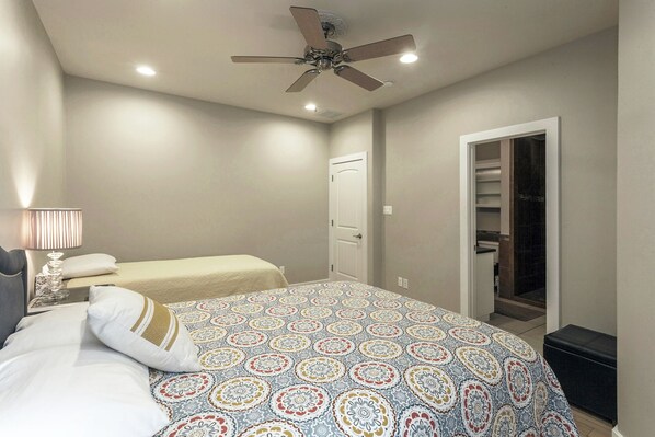 A bedroom with two beds, a ceiling fan, a bedside lamp, and a closet with a mirror. - Huge Home in Downtown ATX/Large Groups Welcome/Walk Everywhere!!! (Austin)