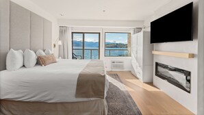 Une chambre moderne avec un grand lit, un téléviseur à écran plat et une vue sur la mer.