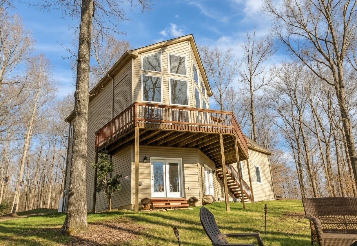 Eine zweistöckige Holzhütte mit Balkon, umgeben von Bäumen.
