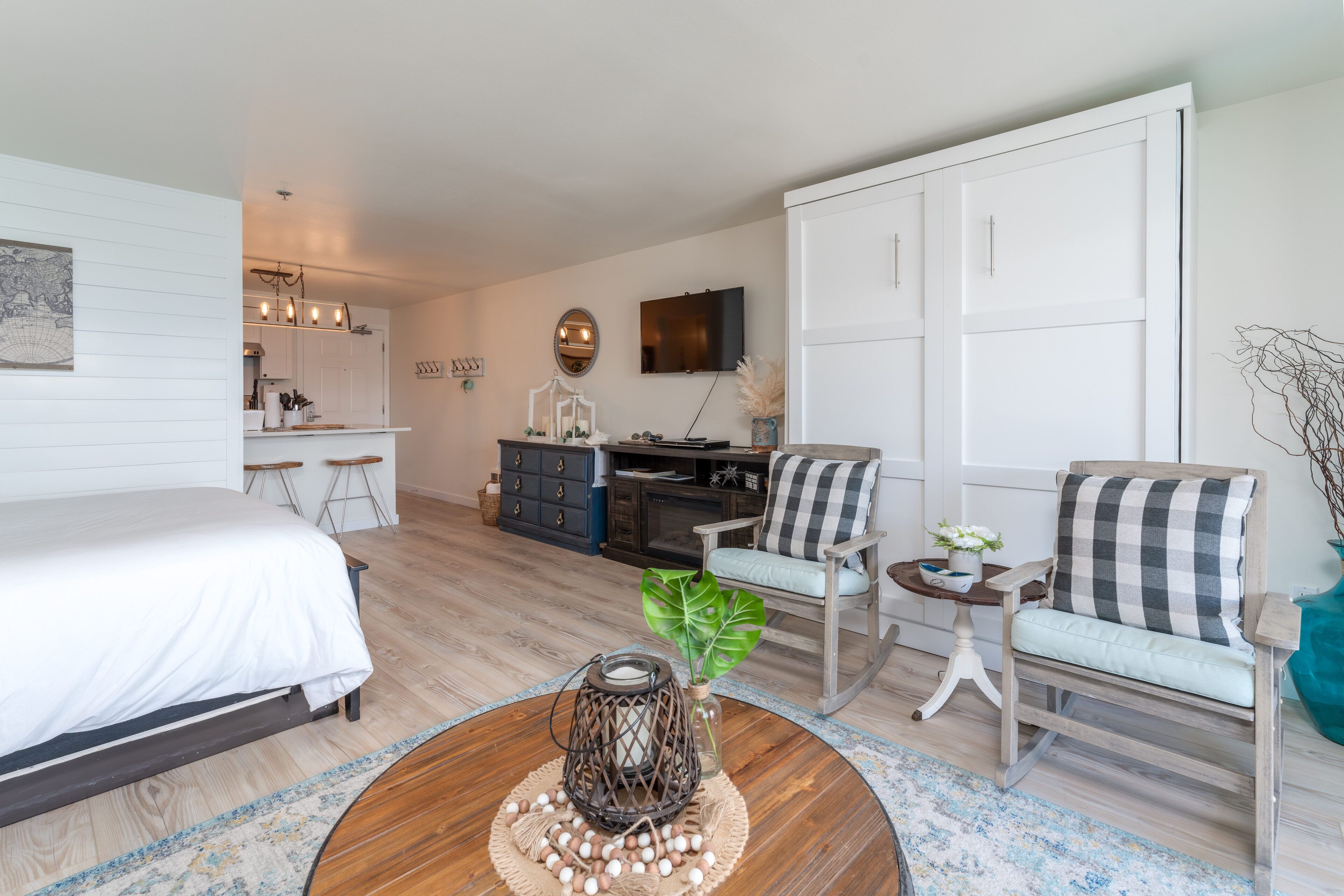 A modern hotel room with a bed, a desk, a chair, and a coffee table.